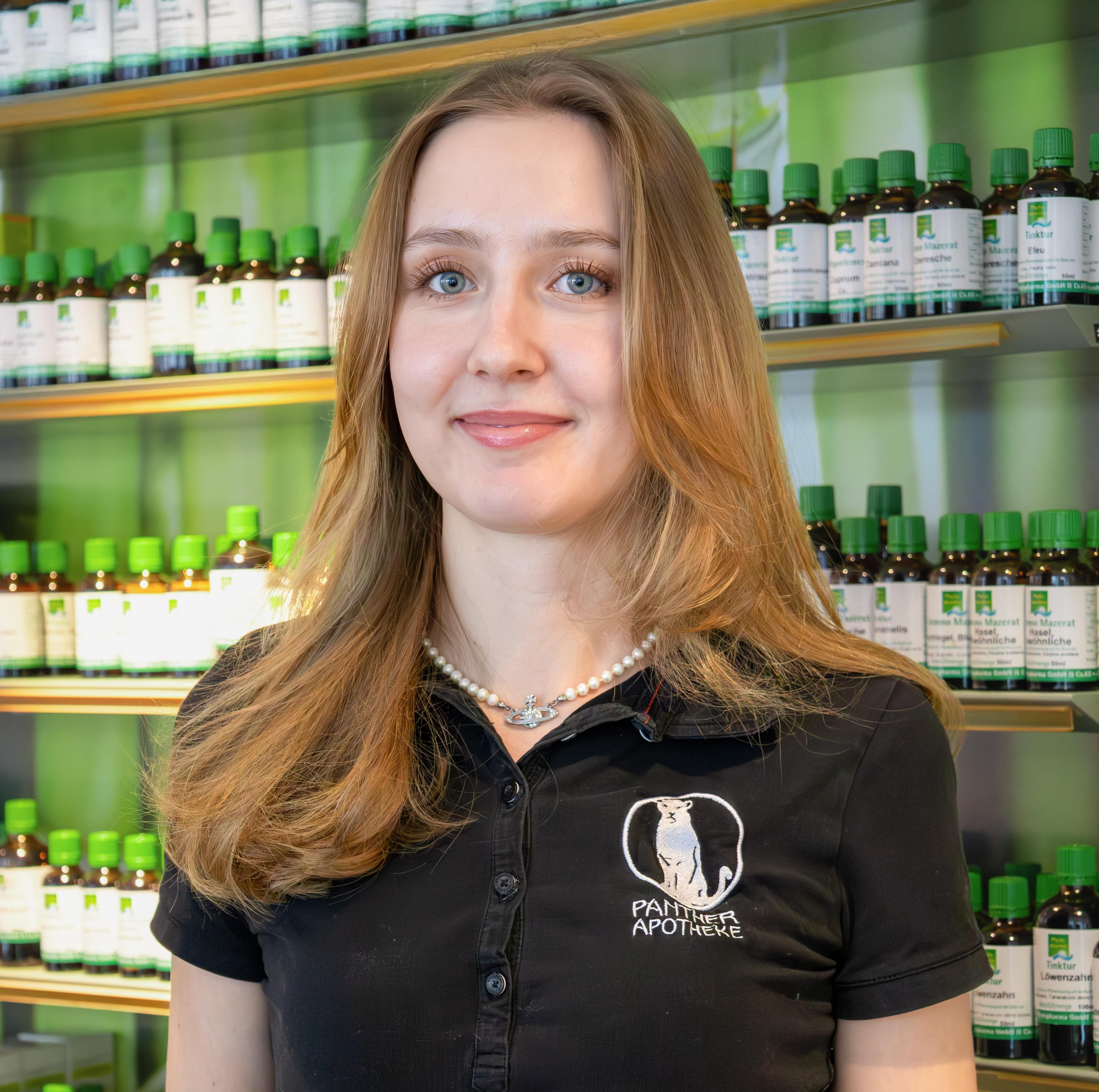 Porträt von Melanie Steinwidder, stehend vor einem Produktregal.
