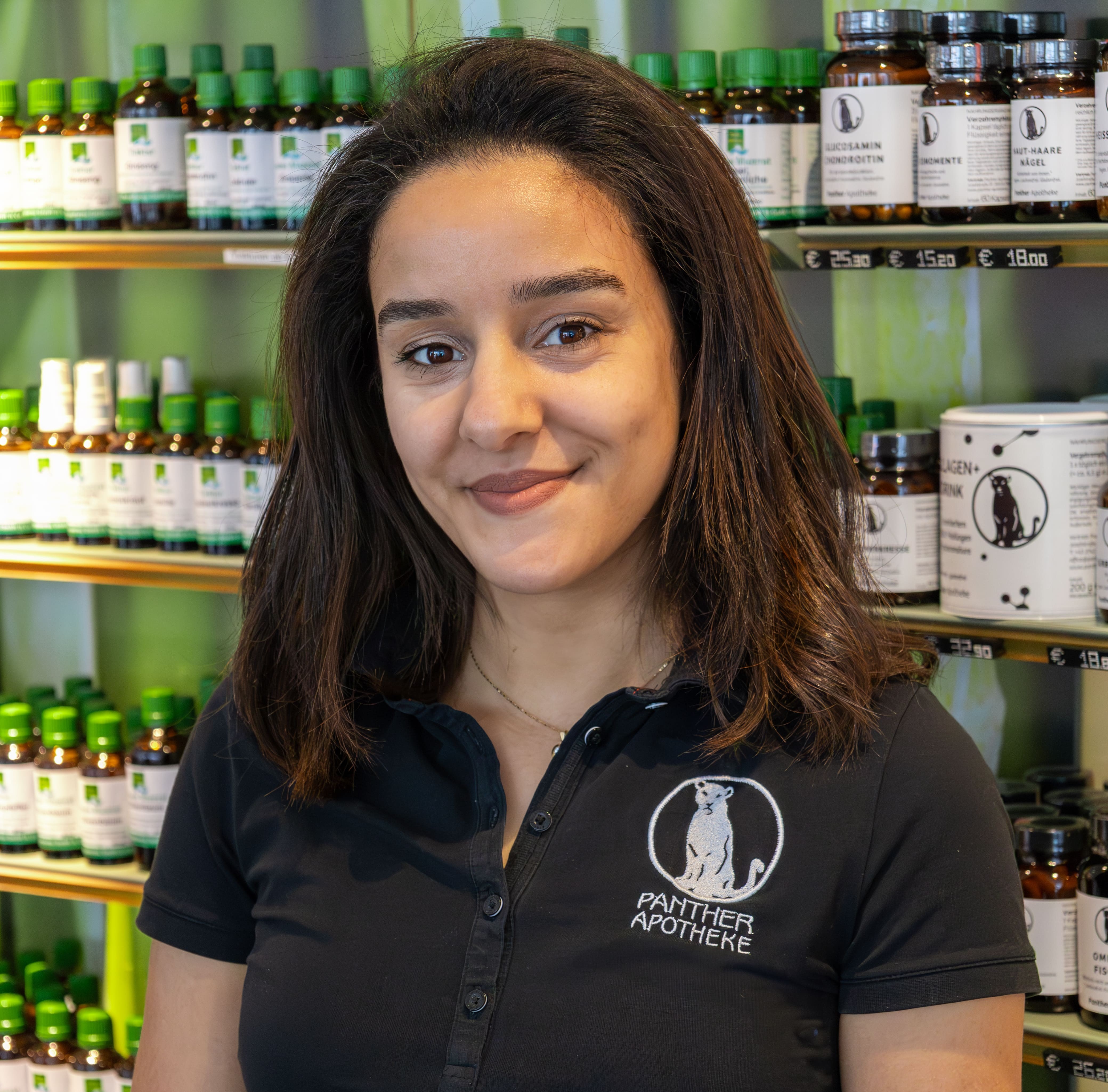 Porträt von Ouiem Ghazouani, stehend vor einem Produktregal.