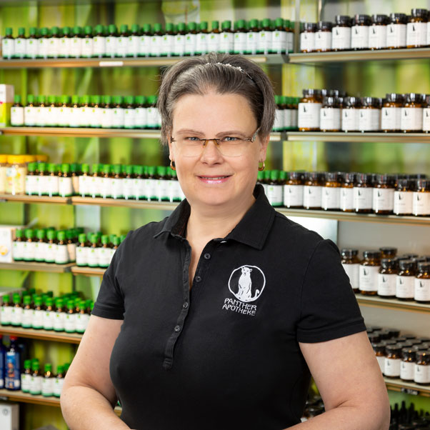 Porträt von Mag. pharm. Susanne Schwarzmayer, stehend vor einem Produktregal.